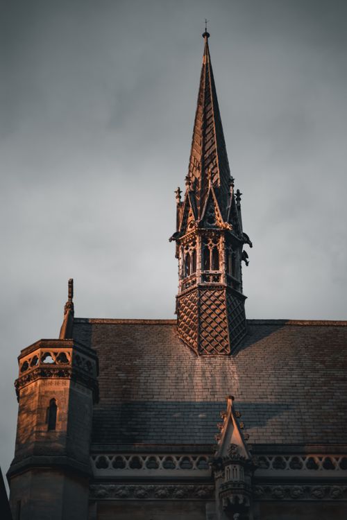 Free Dramatic view of a Gothic-style church spire against an overcast sky in Oxford, England. Stock Photo