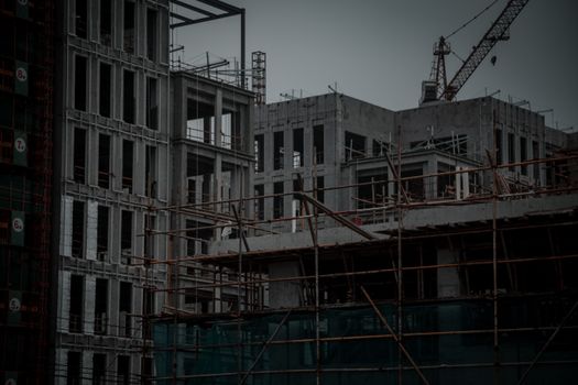 Concrete residential building under construction with crane and scaffolding in Hangzhou, China