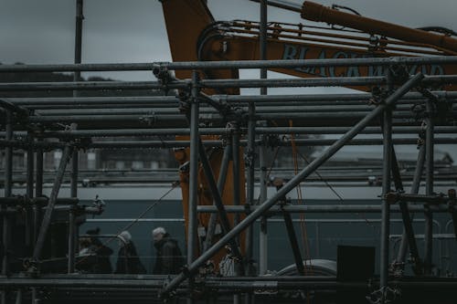 Photo of Grey Pipes with a Yellow Machine in the Background