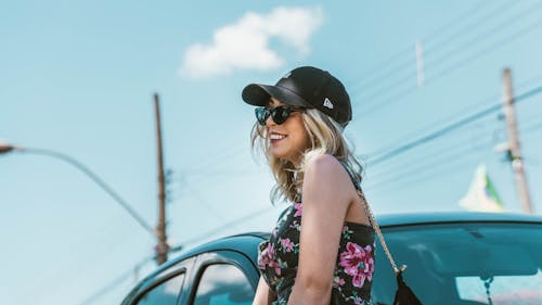 A Woman in Black and Pink Floral Tank Top Wearing Black Hat