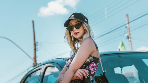 A Woman in Black and Pink Floral Tank Top Wearing Black Hat
