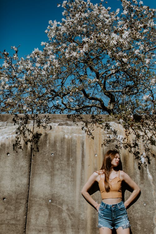 A Woman in Brown Tank Top Standing Under the Tree