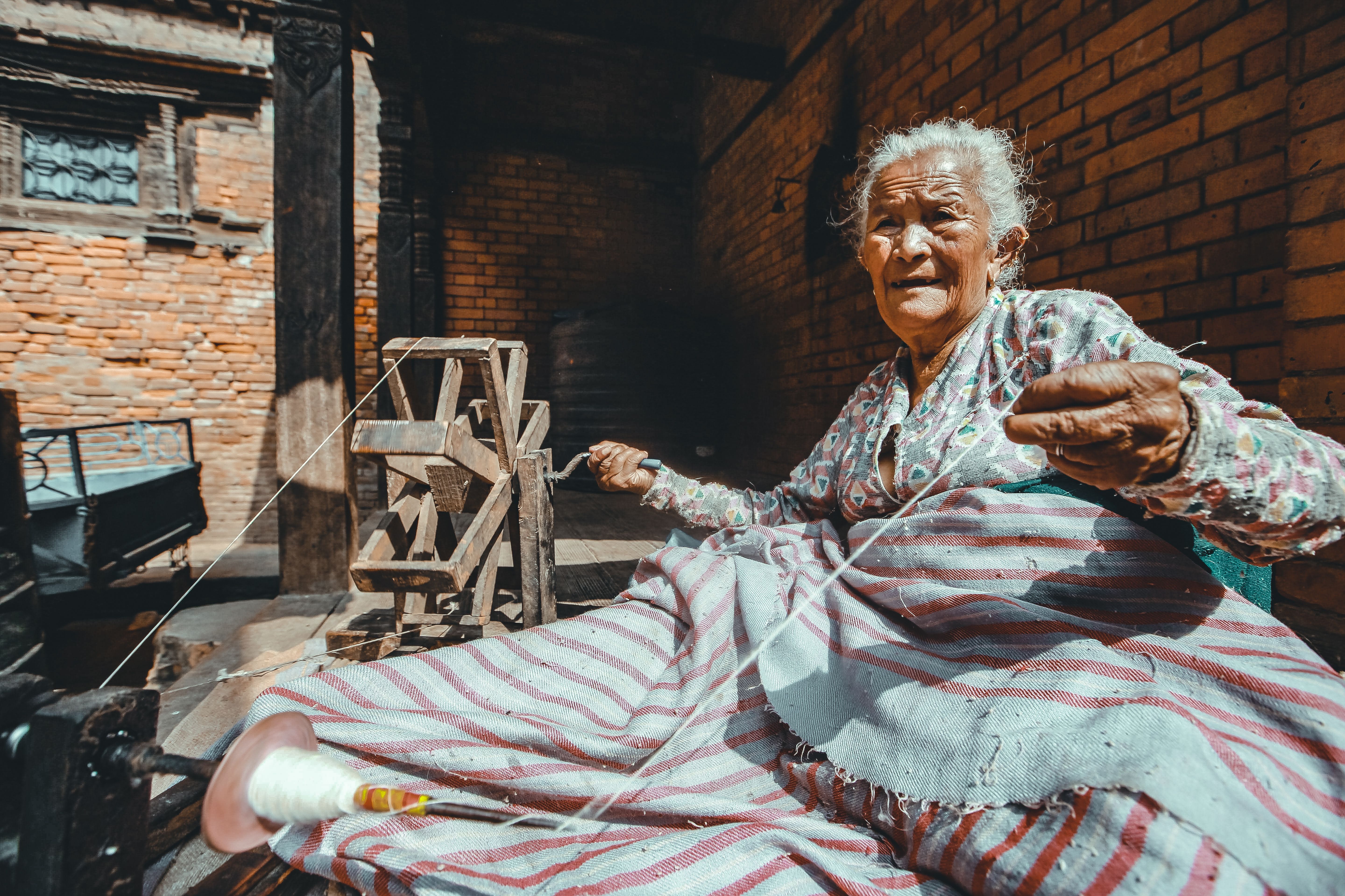 An Elderly Woman Making Thread · Free Stock Photo
