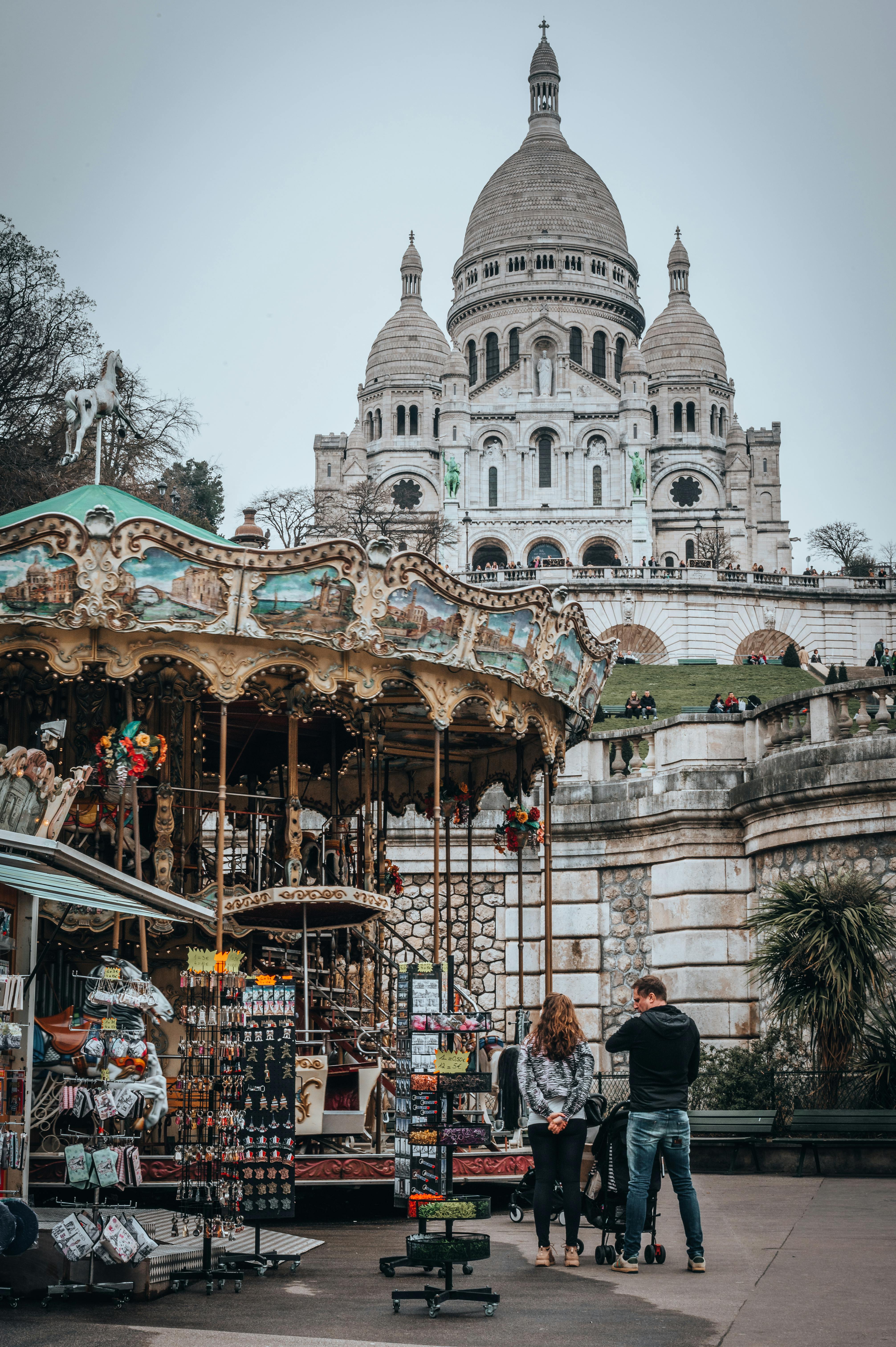 Sacré-Cœur Basilica perched on top of Montmartre hill overlooking the Paris rooftops, its white Romano-Byzantine domes glowing against the sky — one of Paris's most iconic viewpoints