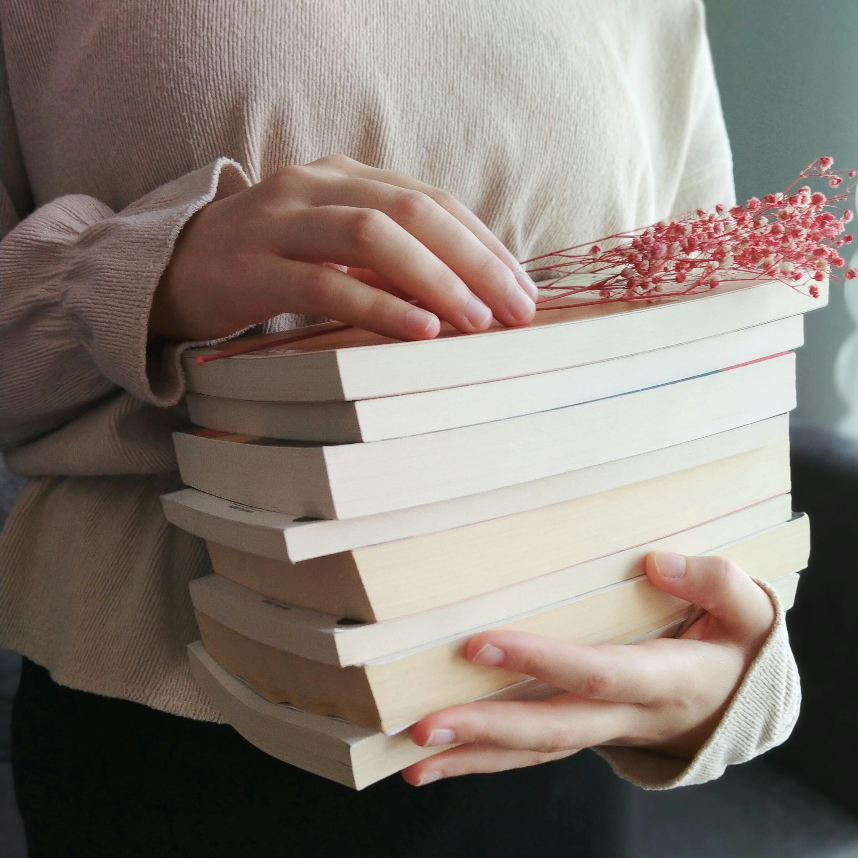 Pile Of Books On Hand · Free Stock Photo