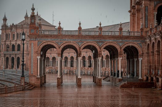 Elegant arches of Plaza de España in Seville, Spain captured during a serene rainy day.