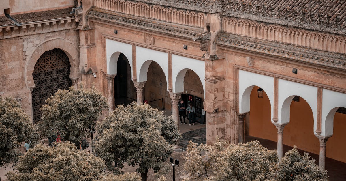 Aerial view of the historic Mosque-Cathedral of Córdoba with its iconic arches and surrounding trees.
