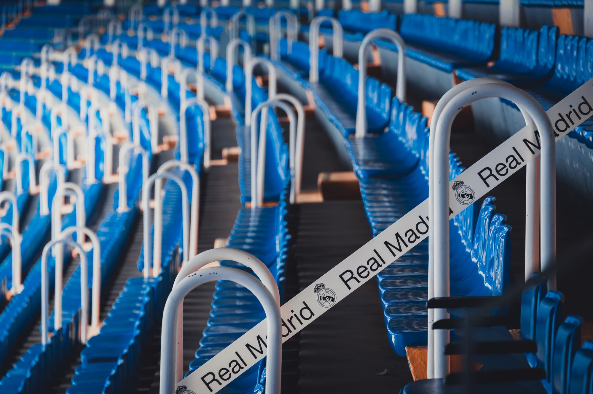 Gradas de un estadio de futbol vacías con asientos azules