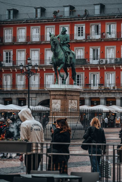 Free Felipe III statue at Plaza Mayor with urban life in Madrid, Spain. Stock Photo