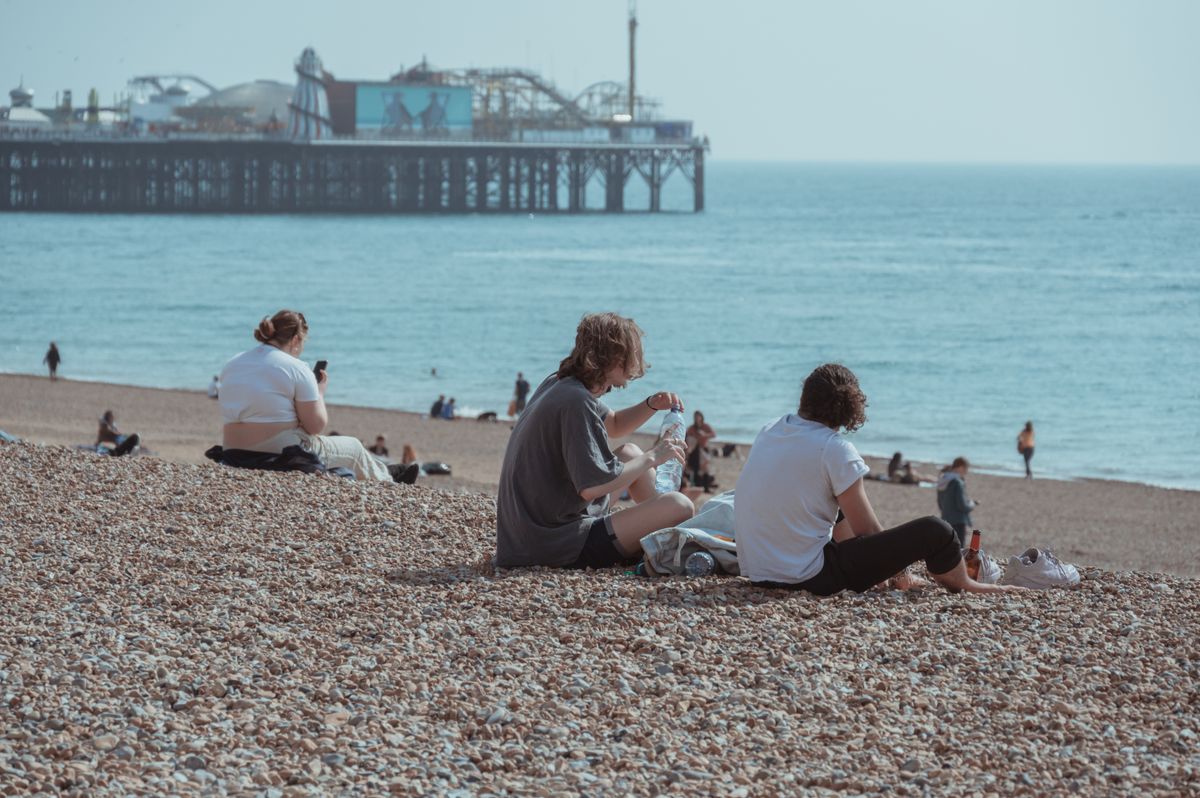 People enjoying Brighton beach with the pier in the background