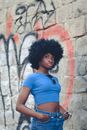 Woman in Crop Top Standing Beside a Stone Wall