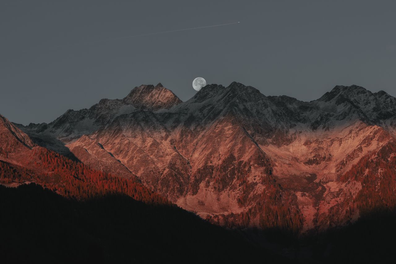 stunning view of mountain peaks under moonlight with a twilight glow c