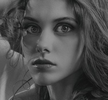 Striking monochrome portrait of a woman with captivating eyes, shot in a studio.