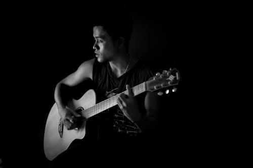 ギターを弾く男のモノクロ写真