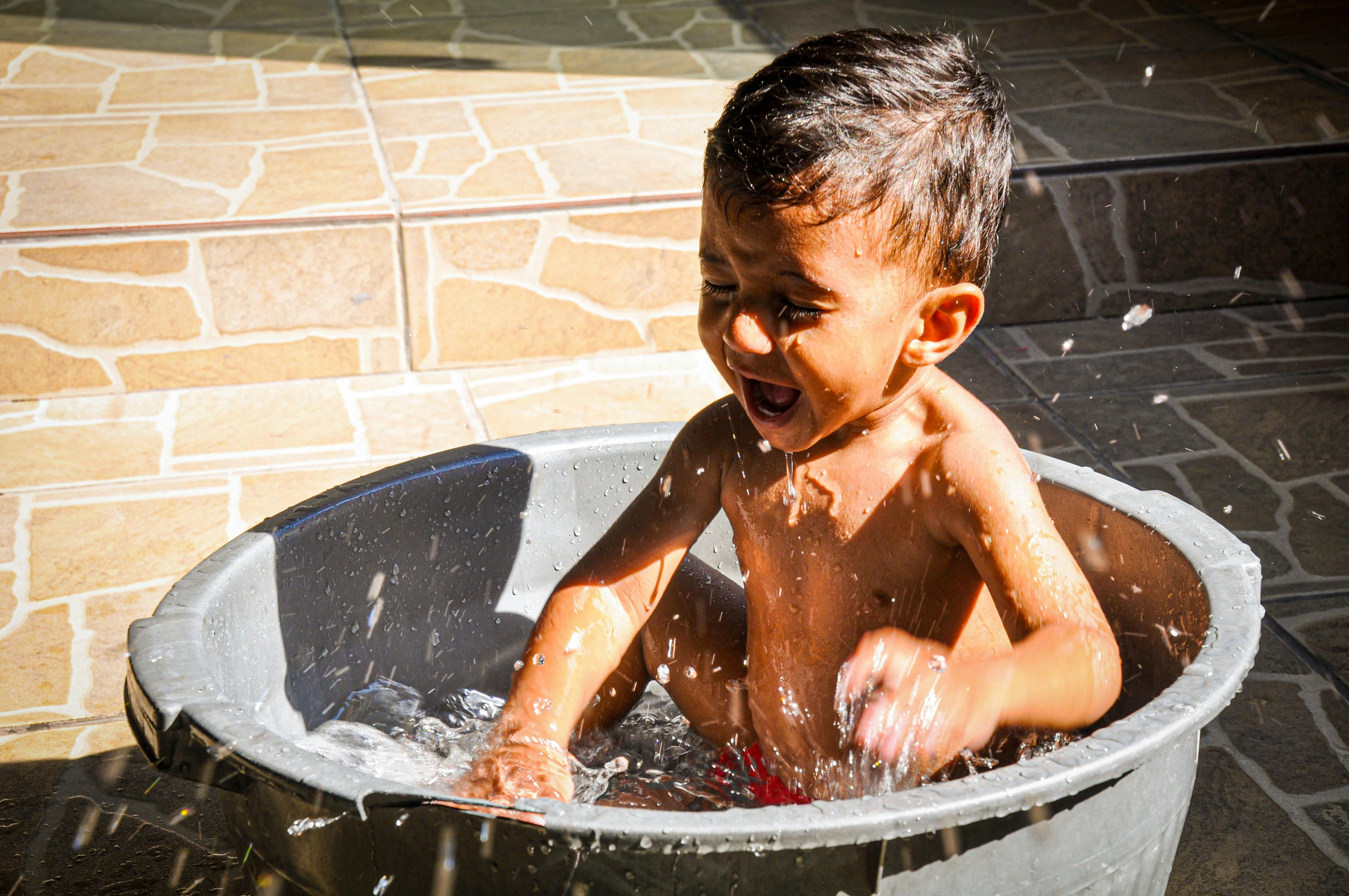 A Boy Bathing in a Bucket · Free Stock Photo