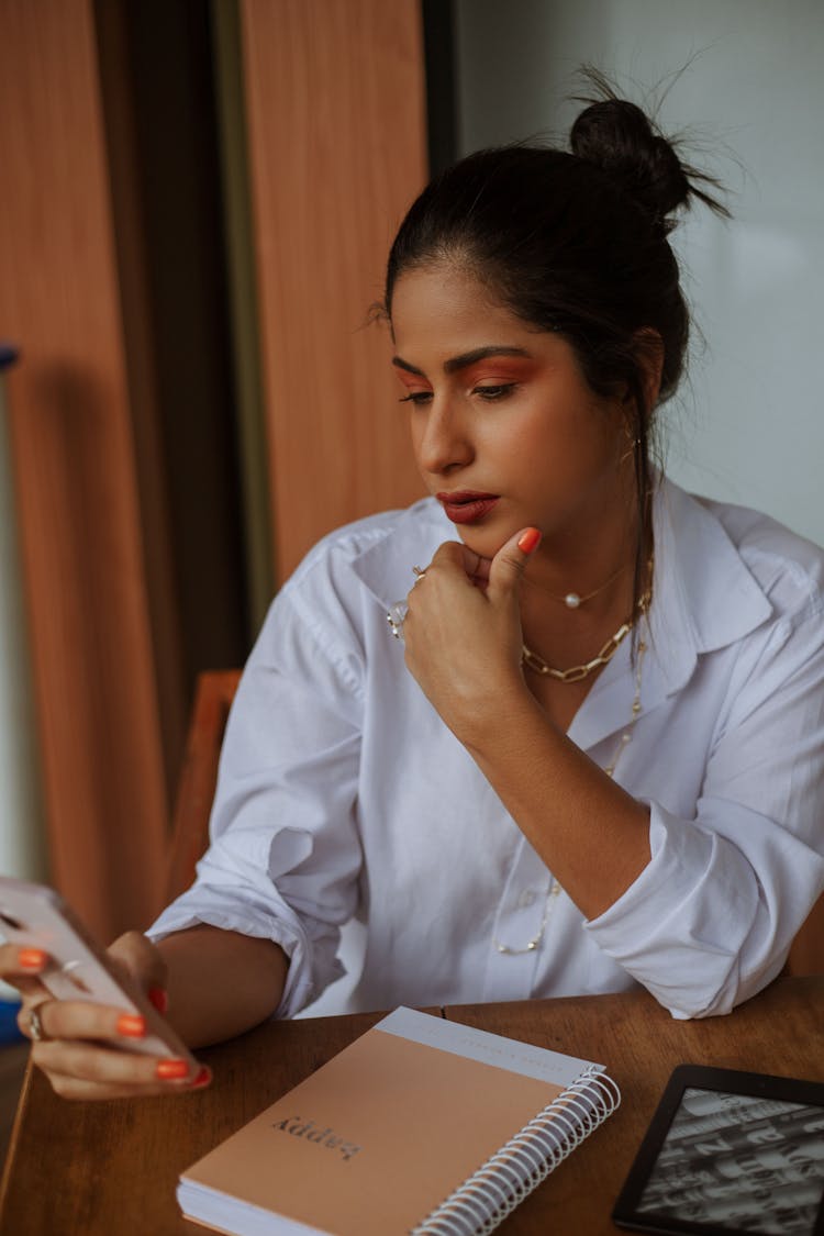 Woman In White Shirt Looking At Smartphone