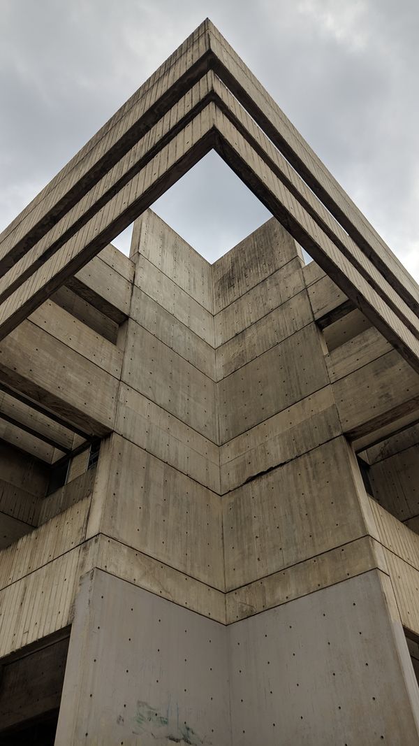Pale concrete facade with punched windows — photo by Juan Diego on Pexels