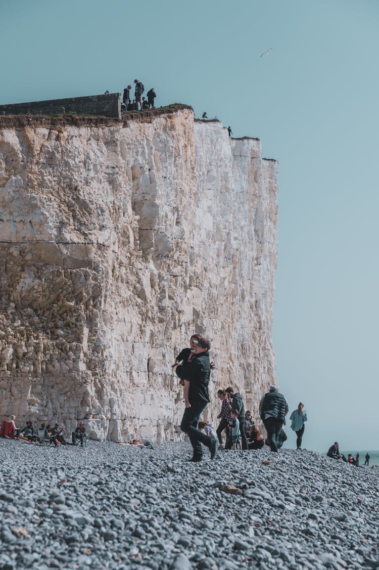 People On Stone Beach Near Cliff