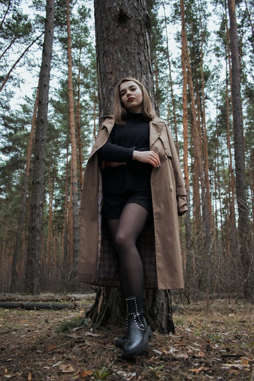 A Woman in Brown Coat Standing in the Woods
