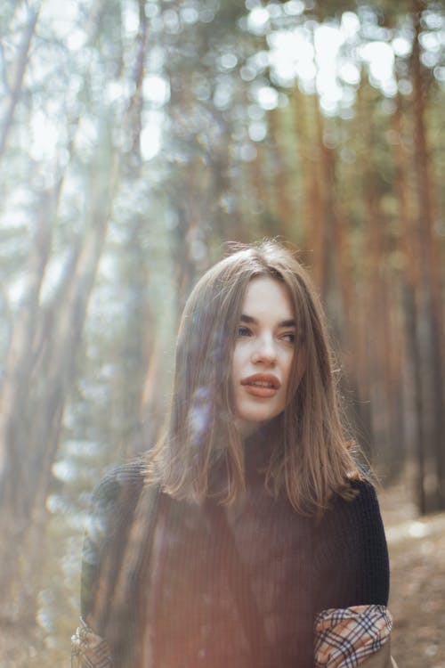 A Woman in Black Turtleneck Sweater Standing in Forest