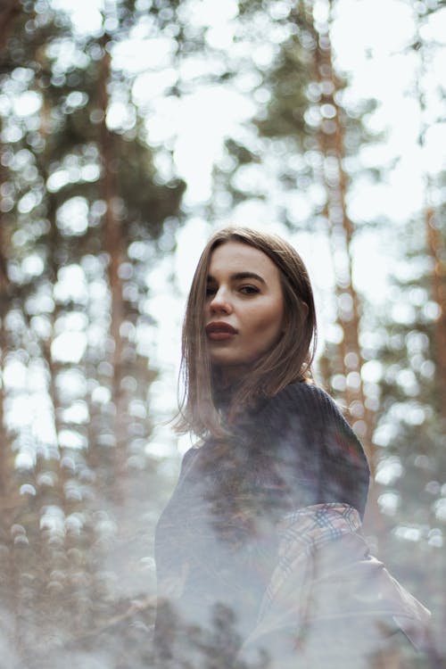 A Woman in Black Sweater Standing in Forest