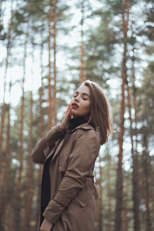 A Woman in Brown Coat Standing Near Trees
