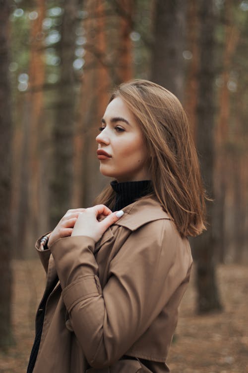 Woman in Brown Coat Standing in the Woods