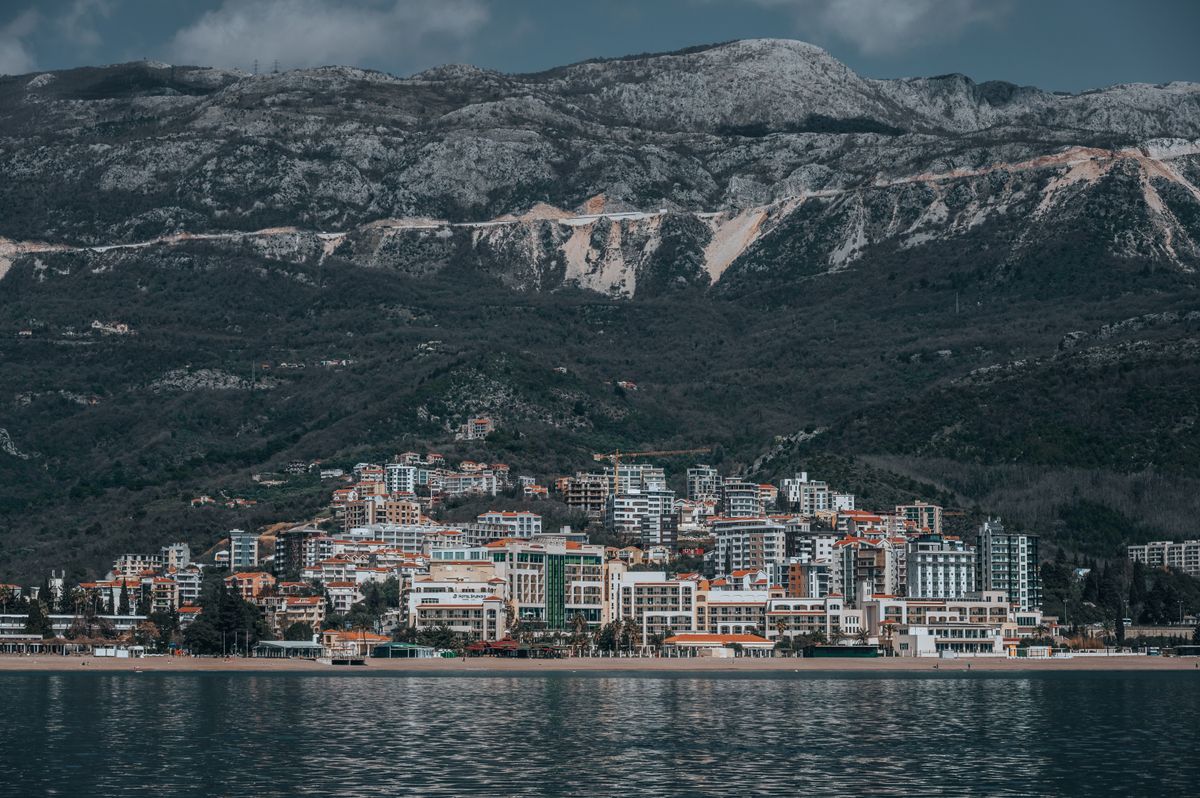 Bečići văzut dinspre mare, cu hoteluri pe coastă și munți în fundal