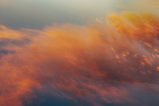 Captivating image of vibrant orange clouds at sunset, creating a serene atmosphere.