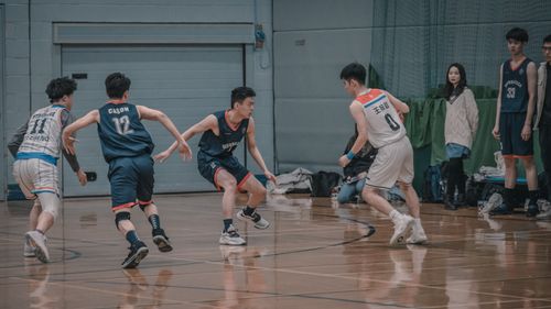 Free Players engage in a competitive basketball game on an indoor court. Stock Photo