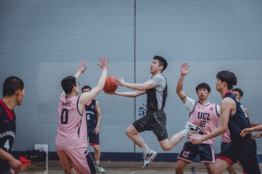 Dynamic image capturing athletes competing in an intense indoor basketball game.