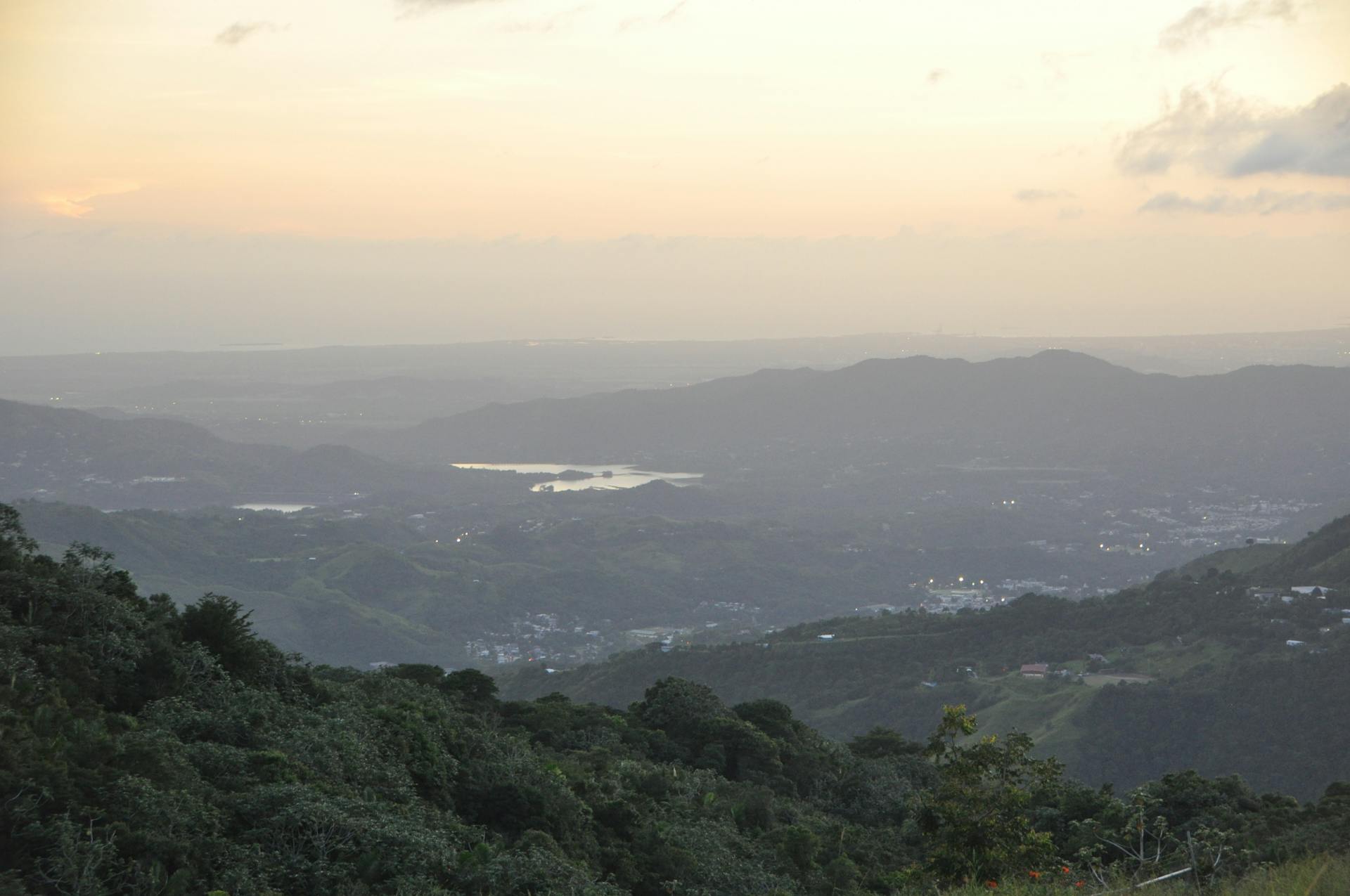 Breathtaking aerial view of lush hills and valleys in Orocovis, Puerto Rico at sunset.