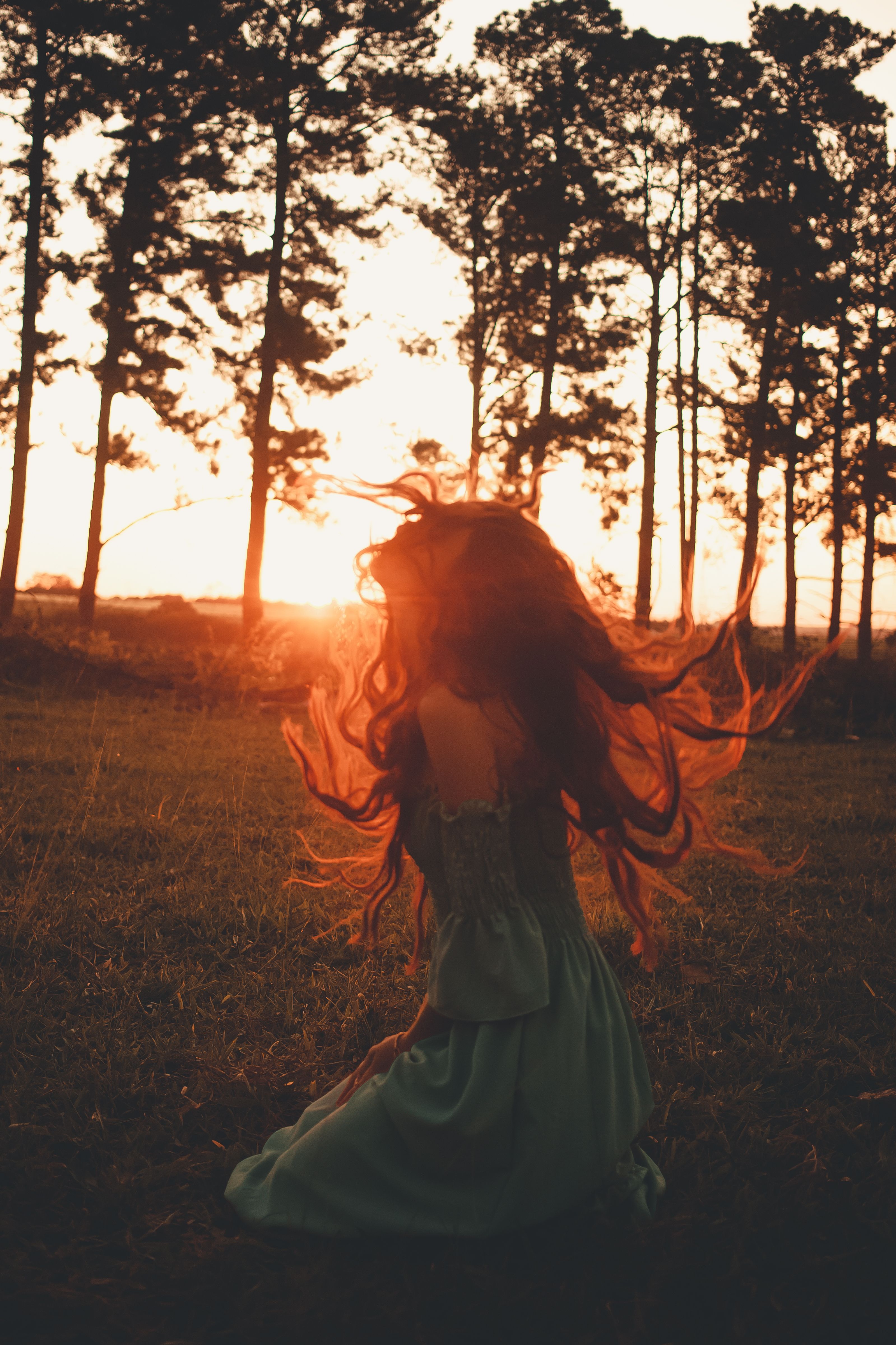 A Woman in Green Dress Sitting on Grass Field during Sunset · Free ...