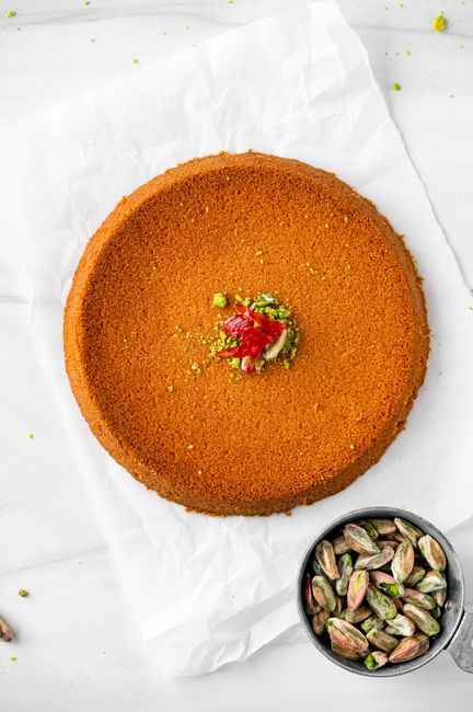 Whole pumpkin pie with visible sunken center depression on white parchment`