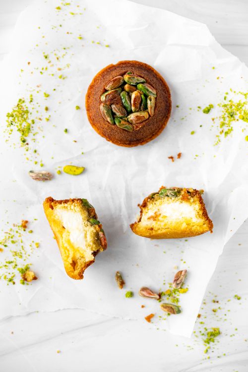 Free Delicious homemade pistachio muffins sliced and styled for food photography on white parchment paper. Stock Photo