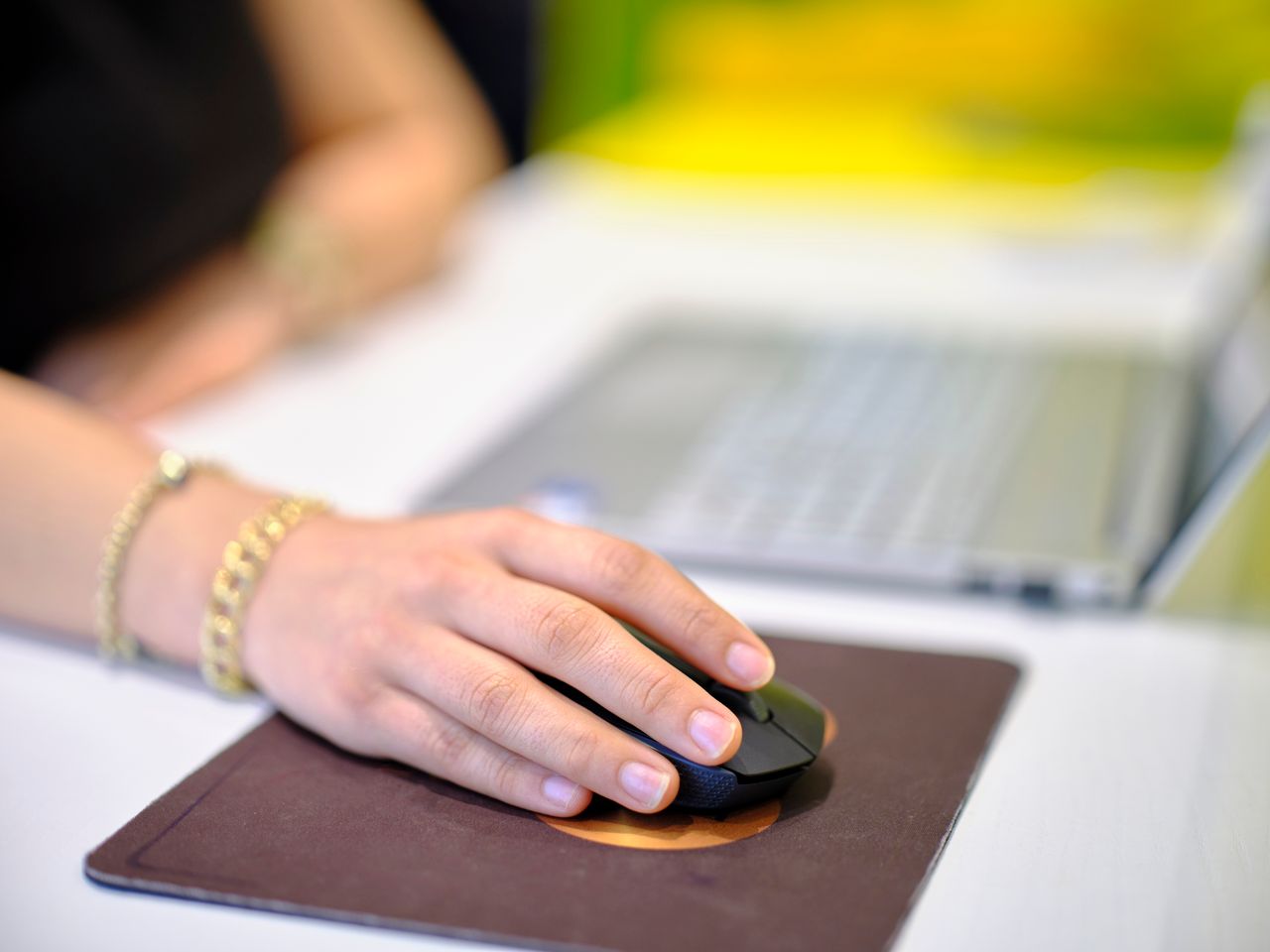 a person using a wireless mouse at a desk perfect for business or tech