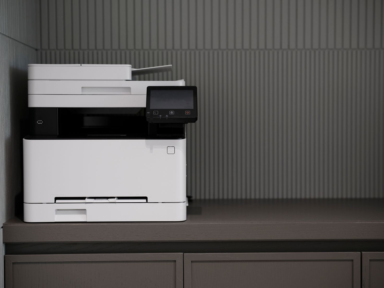 Modern white photocopier machine producing printed page copies