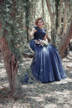 一位身着惊艳蓝色礼服的女士，优雅地坐在森林场景的秋千上