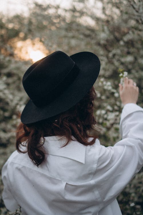 Free Back View of a Woman Wearing White Long Sleeves and Black Fedora Hat Stock Photo