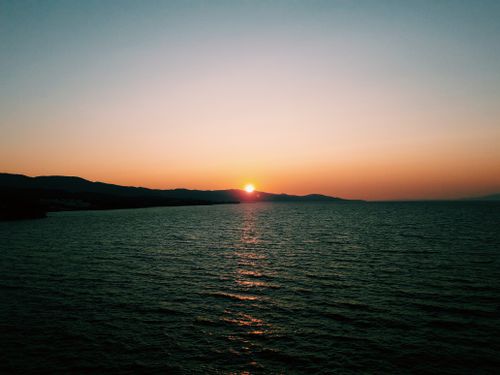 Free A breathtaking ocean sunset with vibrant colors and a tranquil seascape atmosphere. Stock Photo