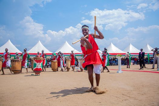 A vibrant drumming celebration in Burundi with performers in traditional attire outdoors.