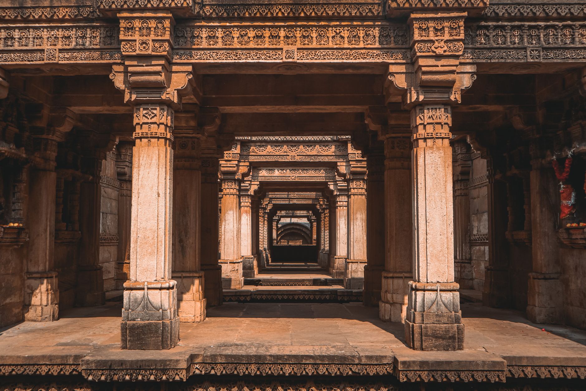 The ornately carved columns inside Adalaj Stepwell - five storeys of sandstone built to keep the water cool and shaded