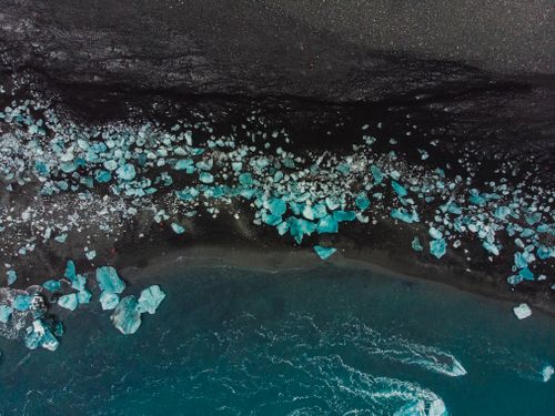 Free A stunning aerial view of icebergs on Iceland's Diamond Beach with black sand and turquoise water. Stock Photo