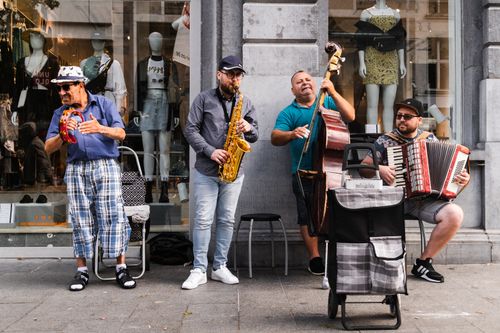 Free Street musicians in Antwerp energizing the crowd with live music. Stock Photo