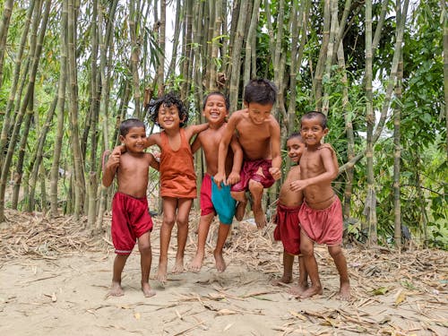 Group of Boys Jumping on Brown Sand