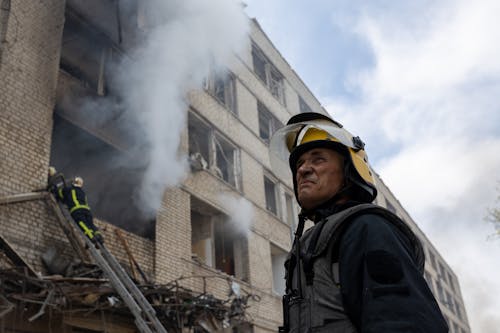 A Firefighter Near a Burning Building 