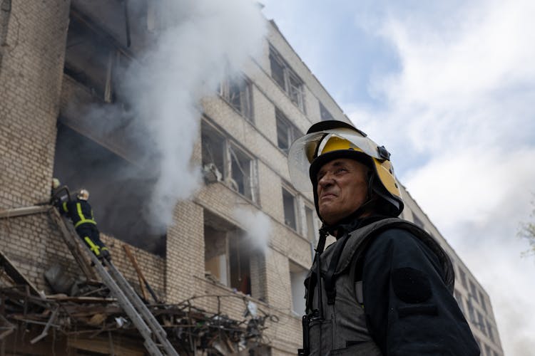 A Firefighter Near A Burning Building 