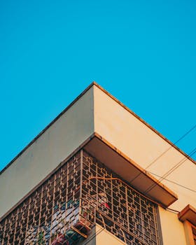 Corner view of a modern building with a blue sky background, showcasing concrete architecture.