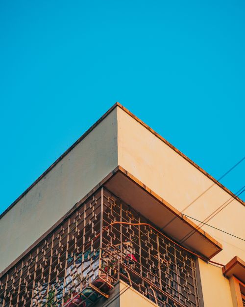 Free Corner view of a modern building with a blue sky background, showcasing concrete architecture. Stock Photo