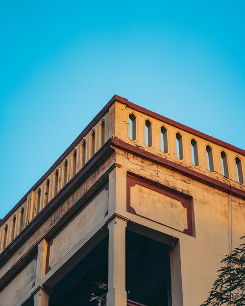 Free Architectural detail of a vintage concrete building with clear blue sky backdrop. Stock Photo